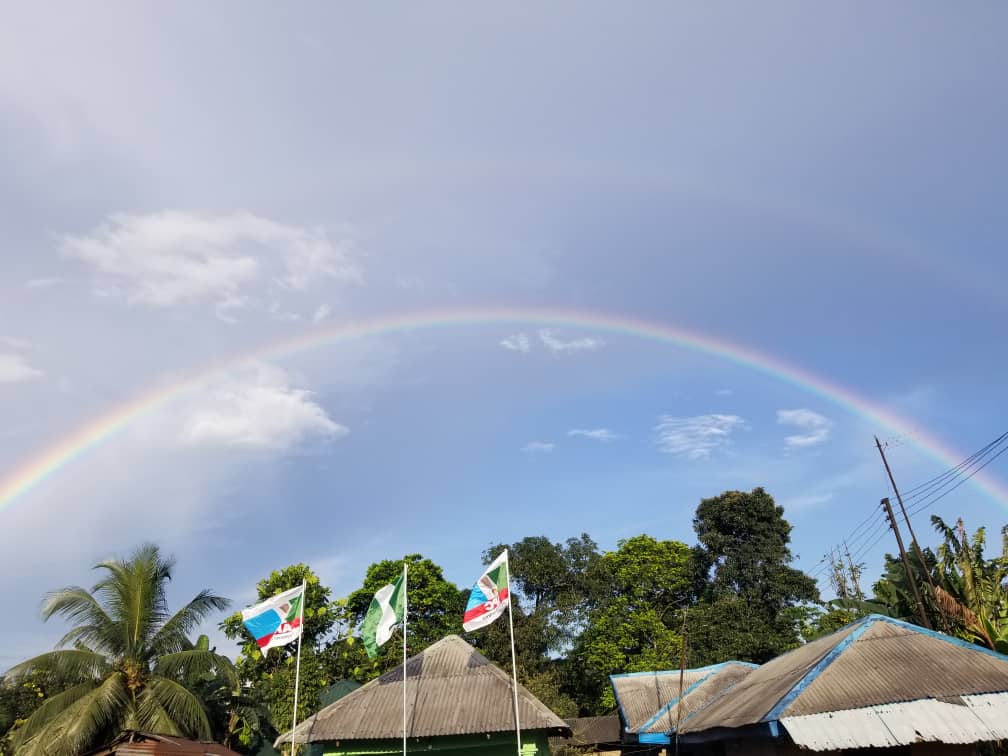 Rainbow across the blue sky with clouds